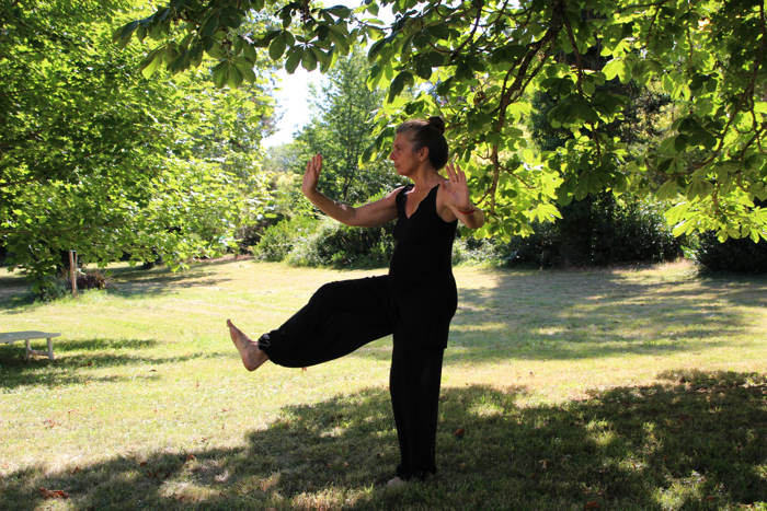 woman doing tai chi in a park